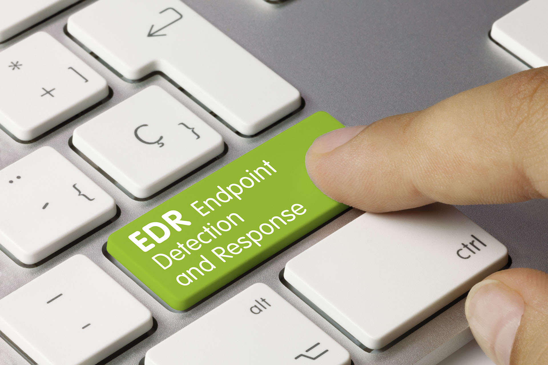 Finger pressing an endpoint detection and response key on a keyboard