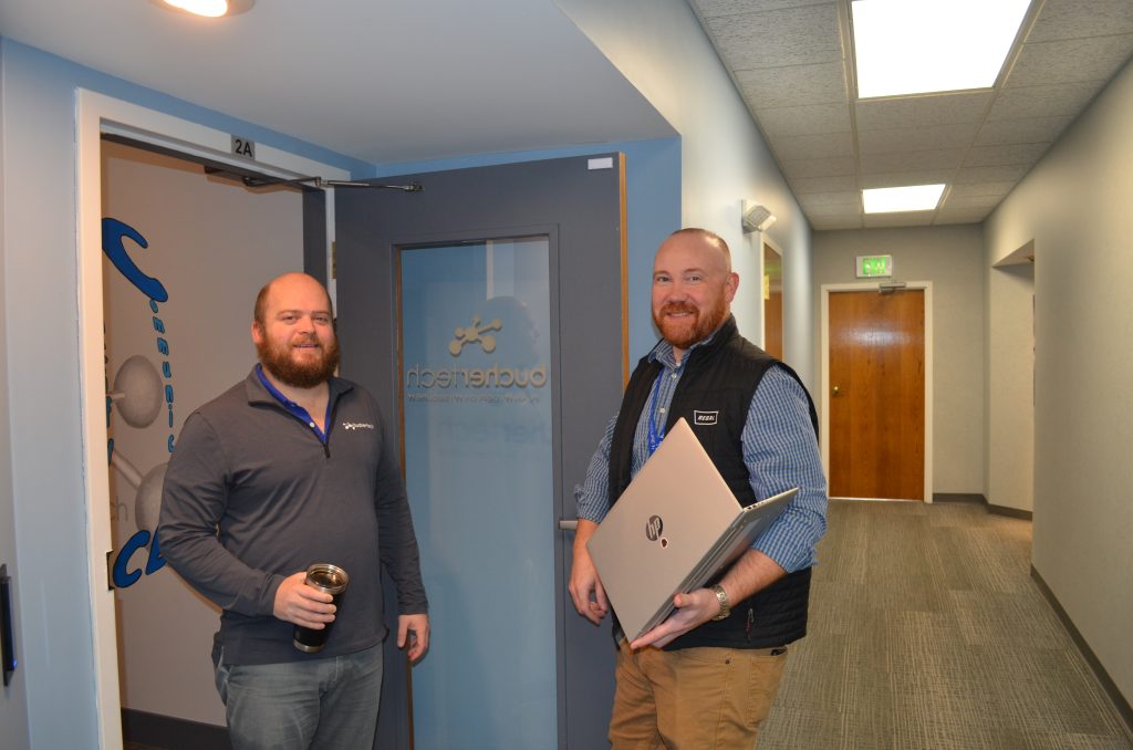 Buchertech technicians carrying equipment down an office hallway