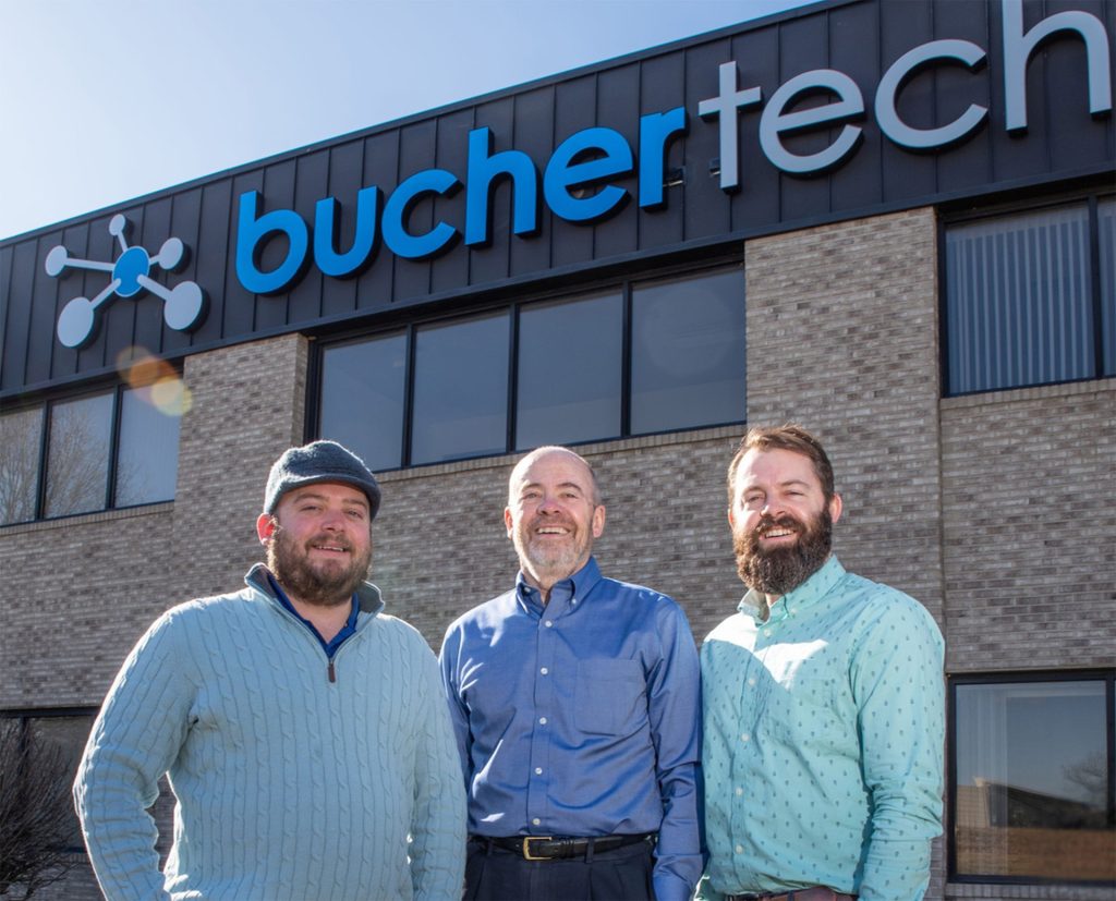 Bucher family members in front of the Buchertech building sign
