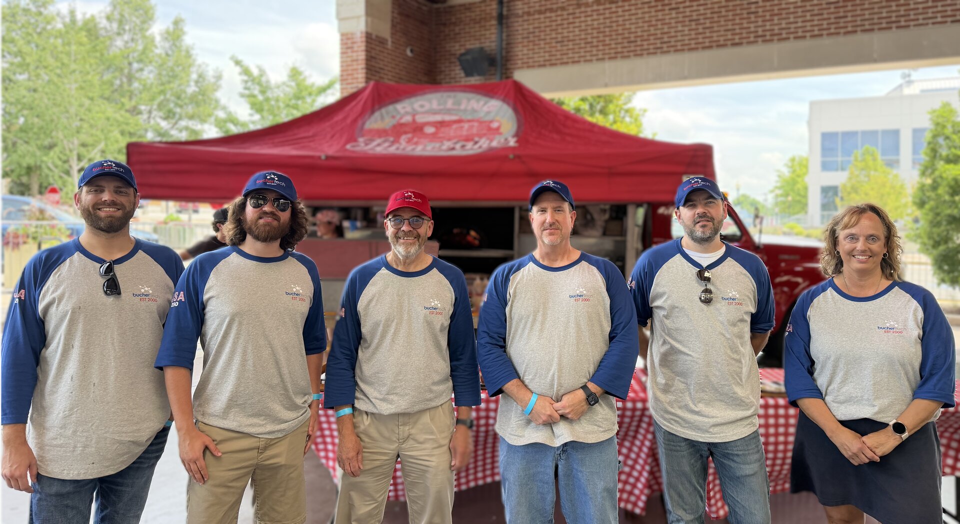Buchertech team under a company tent at a community event